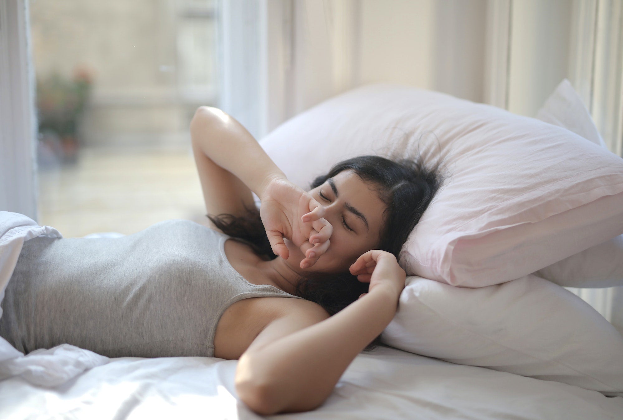 woman with insomnia yawning in bed