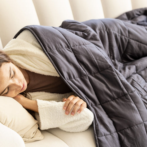 woman laying under weighted blanket