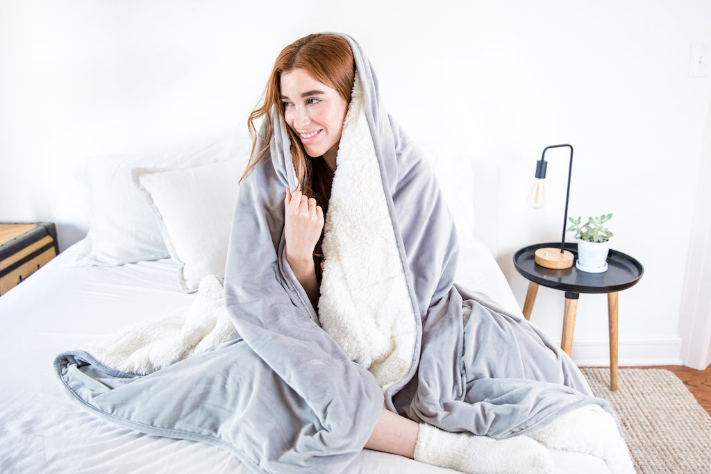 woman snuggling under weighted blanket luna winter