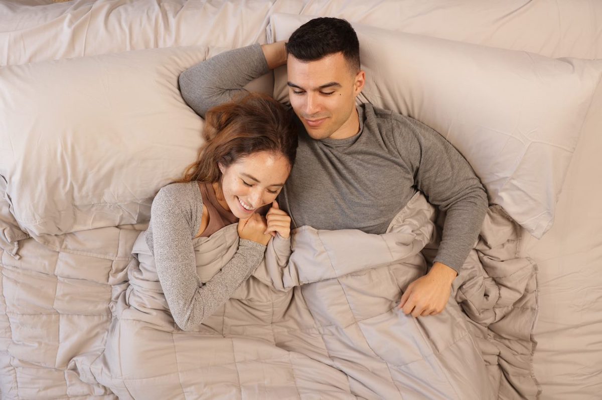 two people cuddling under weighted blanket