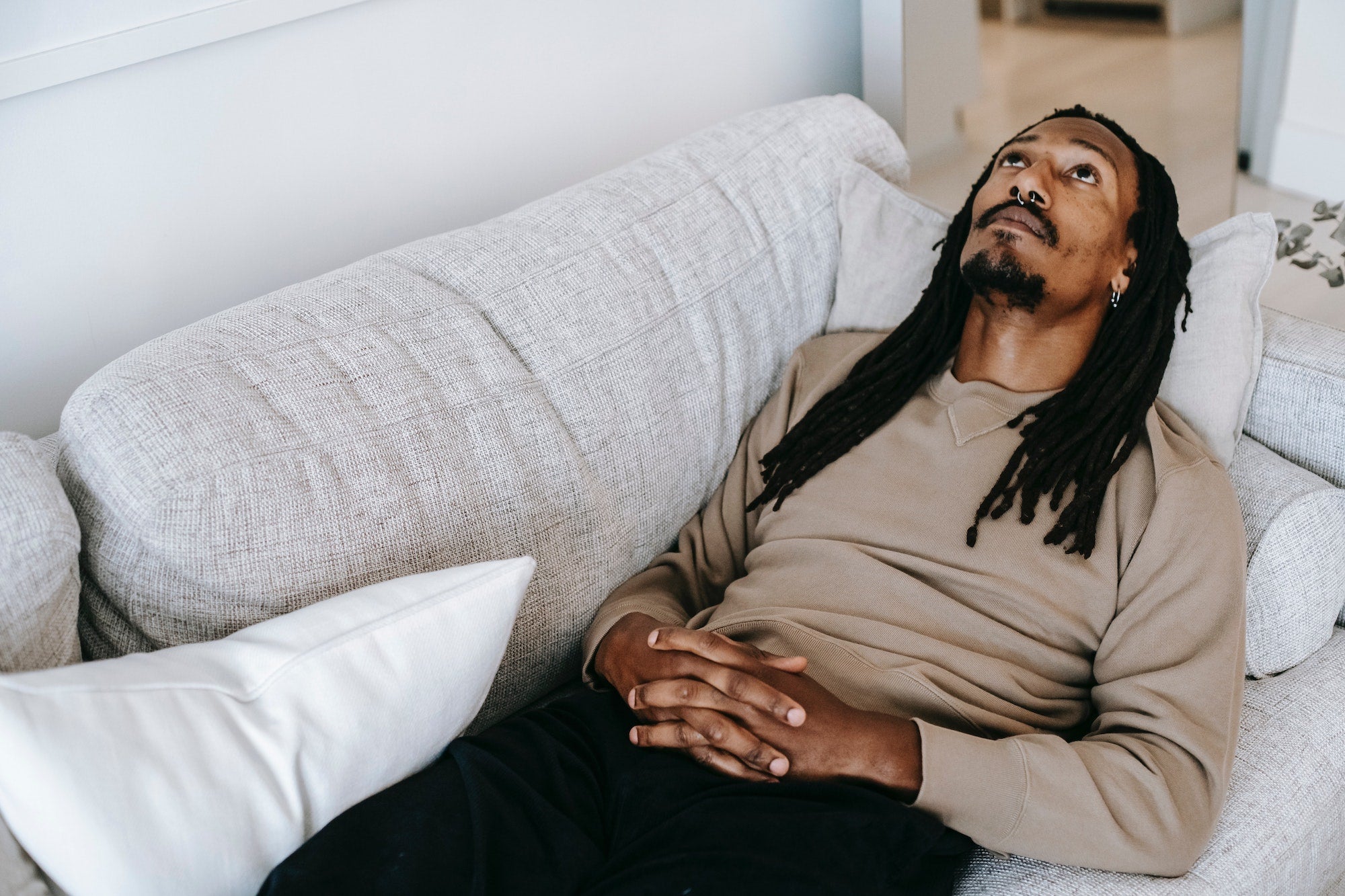 man laying on couch staring in air