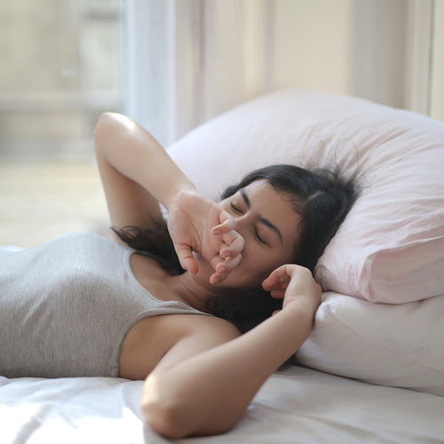woman with insomnia yawning in bed