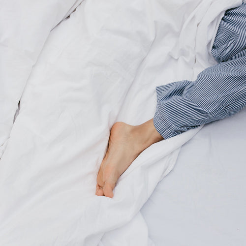 person with leg outside of sheets