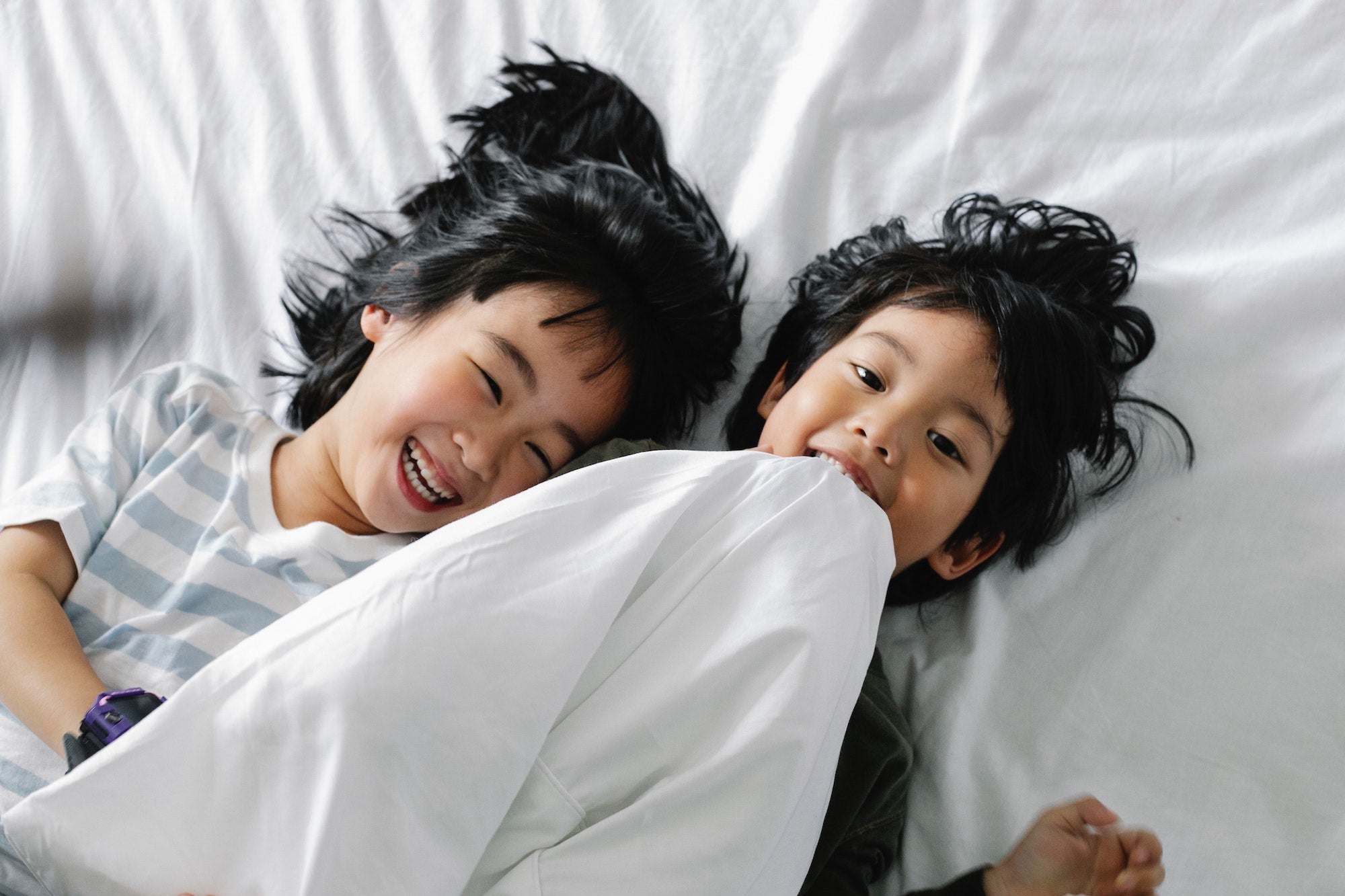 two kids playing with weighted blanket